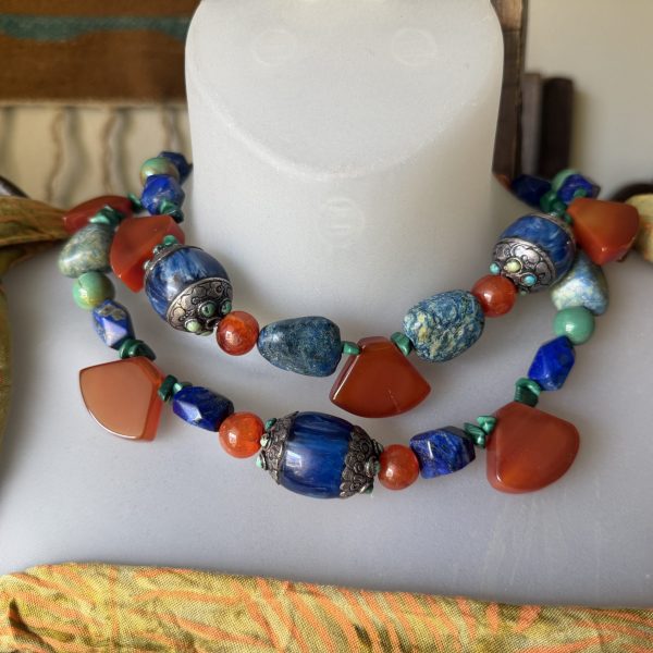 6. This 18” STUNNING double-stranded “Art To Wear” necklace by renowned artist Barbara Wright of Dallas, TX, is in itself, a trip around the world! It is made from handcrafted blue copal beads from Mexico, set in 925 Silver, North American Turquoise cabochons and spheres, gorgeous Lapis Lazuli faceted stones from Afghanistan, Carnelian spheres and 4-sided drops from India , and Malachite and Azurite from Zaire in Africa!