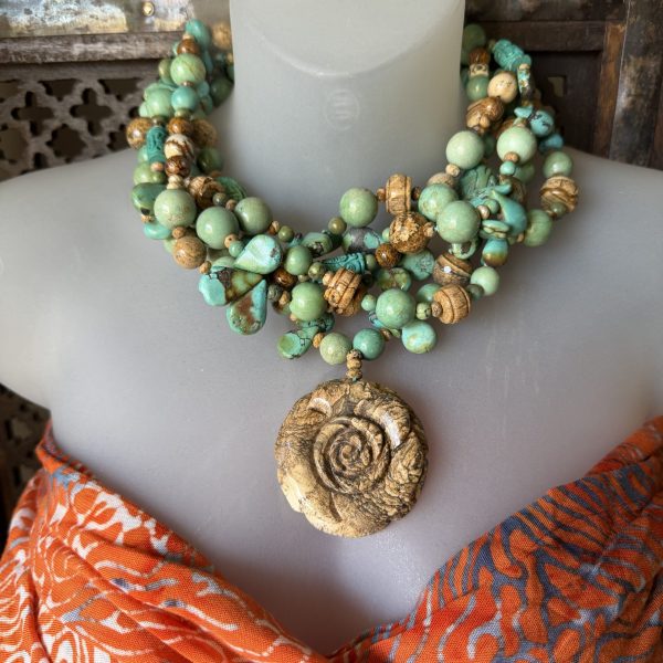 29. This beautiful pendant necklace features a gorgeous beige pendant carved into a rose form Jasper accentuated by with turquoise beads, set in silver by artist Barbara Wright. The piece is handcrafted and has a 925 silver metal purity.