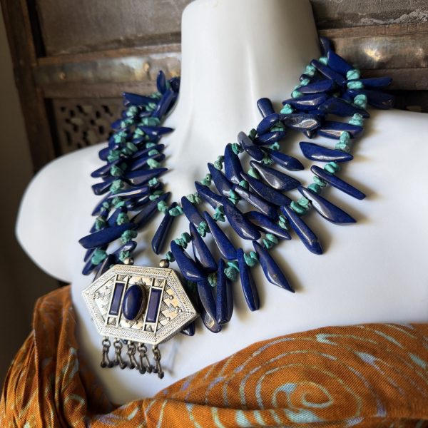 1. This is a triple-stranded necklace featuring an Antique Afghan Amulet Box pendant with lapis lazuli and turquoise beads by Barbara Wright of Dallas, Texas, is a stunning piece of jewelry! The antique, Sterling Silver rectangular-shaped pendant features beautiful lapis lazuli stones and is complemented by turquoise beads and lapis beads!