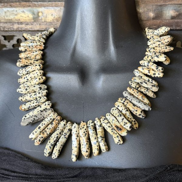 16. The Dalmatian Jasper Necklace by Dallas, TX artist, Barbara Wright is a unique piece of hand-knotted jewelry on silk thread, measuring 20 inches in length. Made with high-quality ethically- sourced stunning Dalmatian Jasper, this necklace is a stylish accessory that adds a touch of artistry to any outfit.
