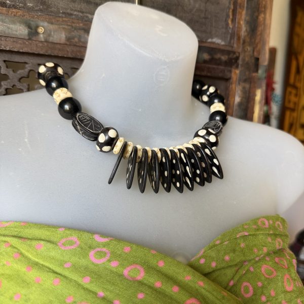 2. This African Handmade Beaded Necklace is a unique piece of artisanal jewelry designed by Barbara Wright of Dallas,Texas. The black and white hand made batik beads are accented with black jade stones, showcasing an authentic African design. The necklace has a length of 19.5 inches, making it a versatile accessory that can be worn for various occasions. The Tribal aesthetic adds a touch of exclusivity to this ethnic and regional style piece, making it a standout addition to any jewelry collection.