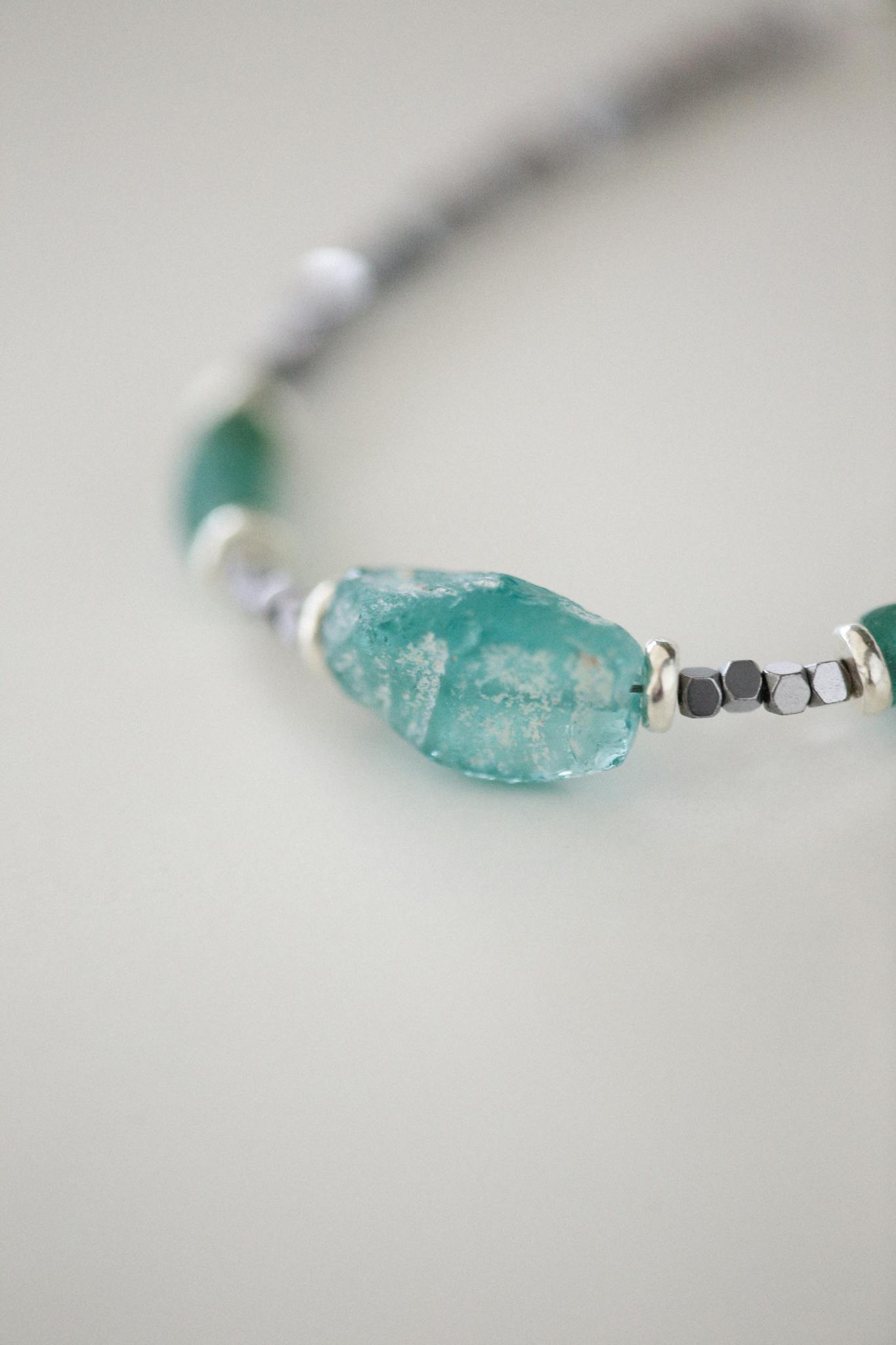 Close-up of an elegant gemstone bracelet featuring blue and silver beads.