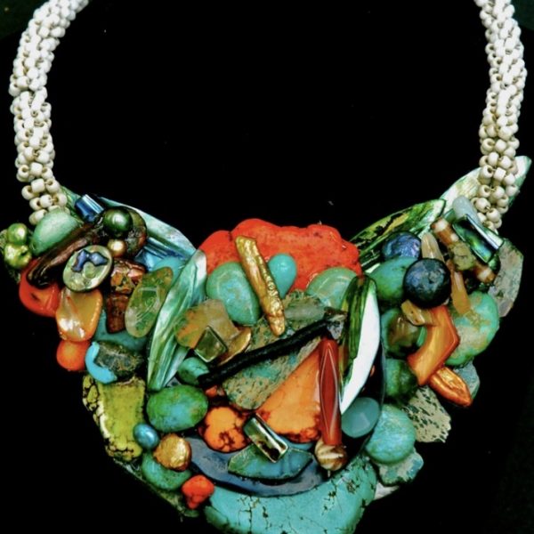 This beautiful choker-style necklace by Jo Anne Brooks offers a multitude of colors and materials.! With gorgeous chunks of turquoise , Howlite, coral, bone, African glass beads, Freshwater pearls, Carnelian, amber , Mother-of -Peal and more. One is able to see in this piece is jewelry all of the colors in an Arizona sunset.